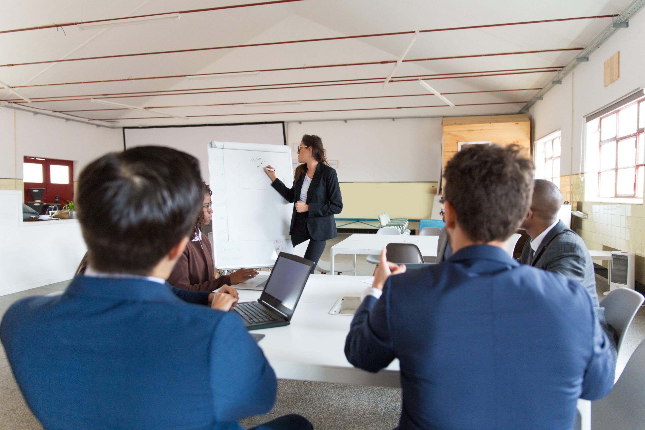 Confident female businesswoman drawing on whiteboard